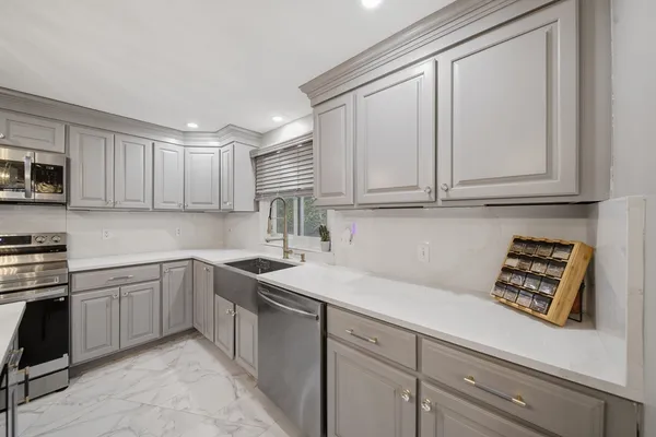 a kitchen with sink cabinets and appliances