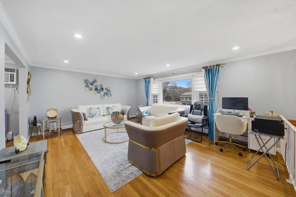 a living room with furniture and a wooden floor