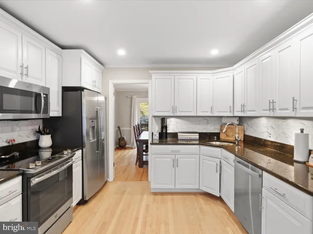 a kitchen with a sink a refrigerator and cabinets