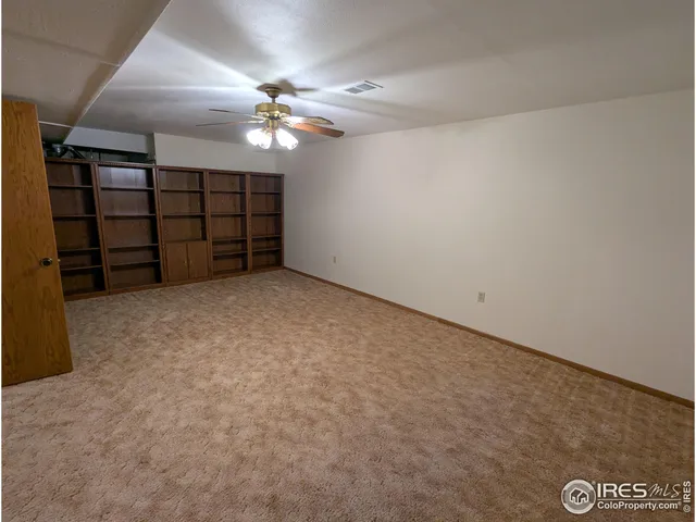 an empty room with a ceiling fan and a window