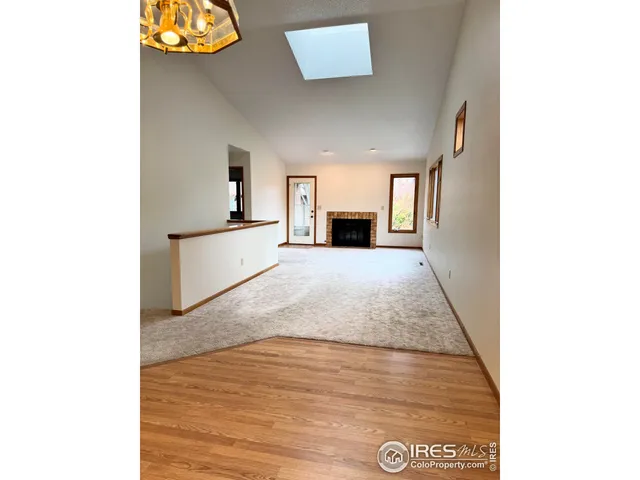 an empty room with wooden floor cabinet and windows