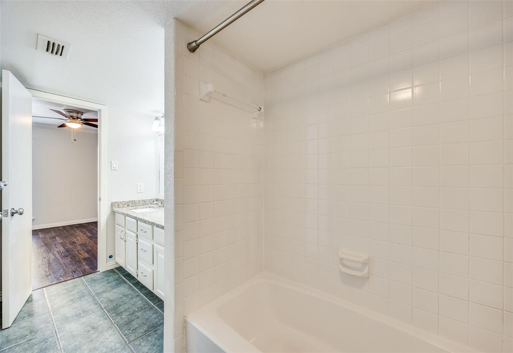 13220 Woodbend Lane Dallas, TX 75243 - Photo 21 of 26 a bathroom with a granite countertop sink a toilet and shower