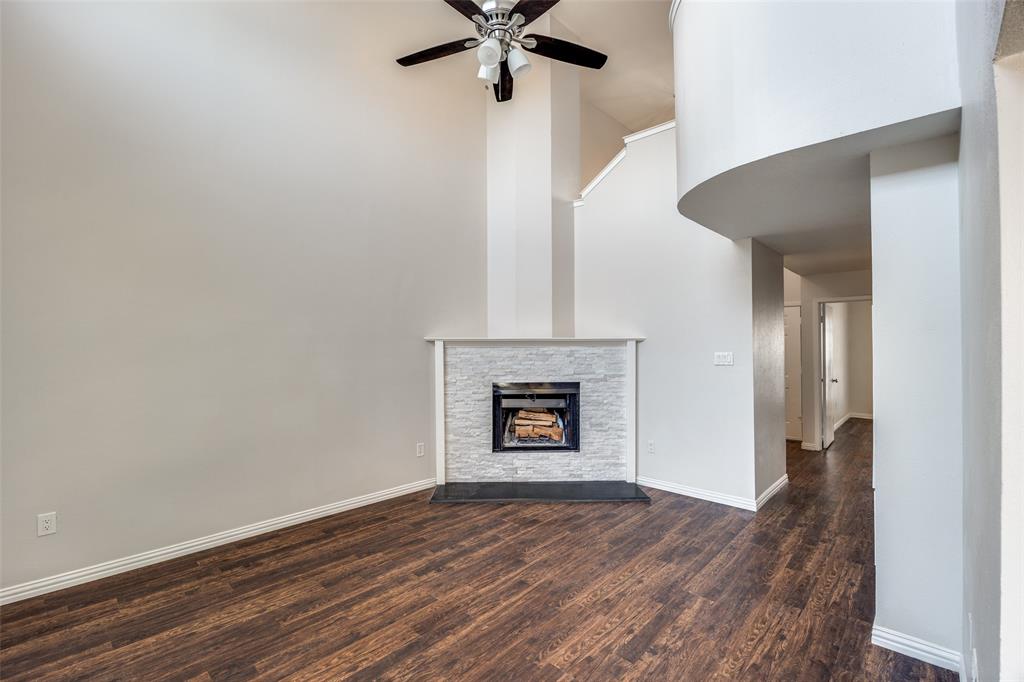 13220 Woodbend Lane Dallas, TX 75243 - Photo 3 of 26 a view of an empty room with a fireplace and a ceiling fan