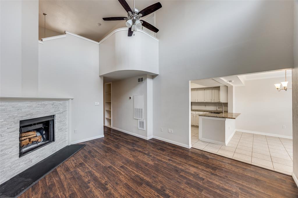 13220 Woodbend Lane Dallas, TX 75243 - Photo 5 of 26 a empty room with a fireplace and wooden floor