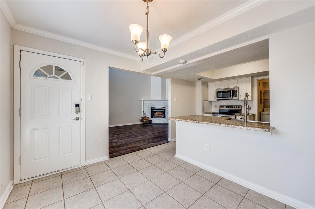 13220 Woodbend Lane Dallas, TX 75243 - Photo 7 of 26 a large white kitchen with granite countertop a refrigerator and a stove top oven