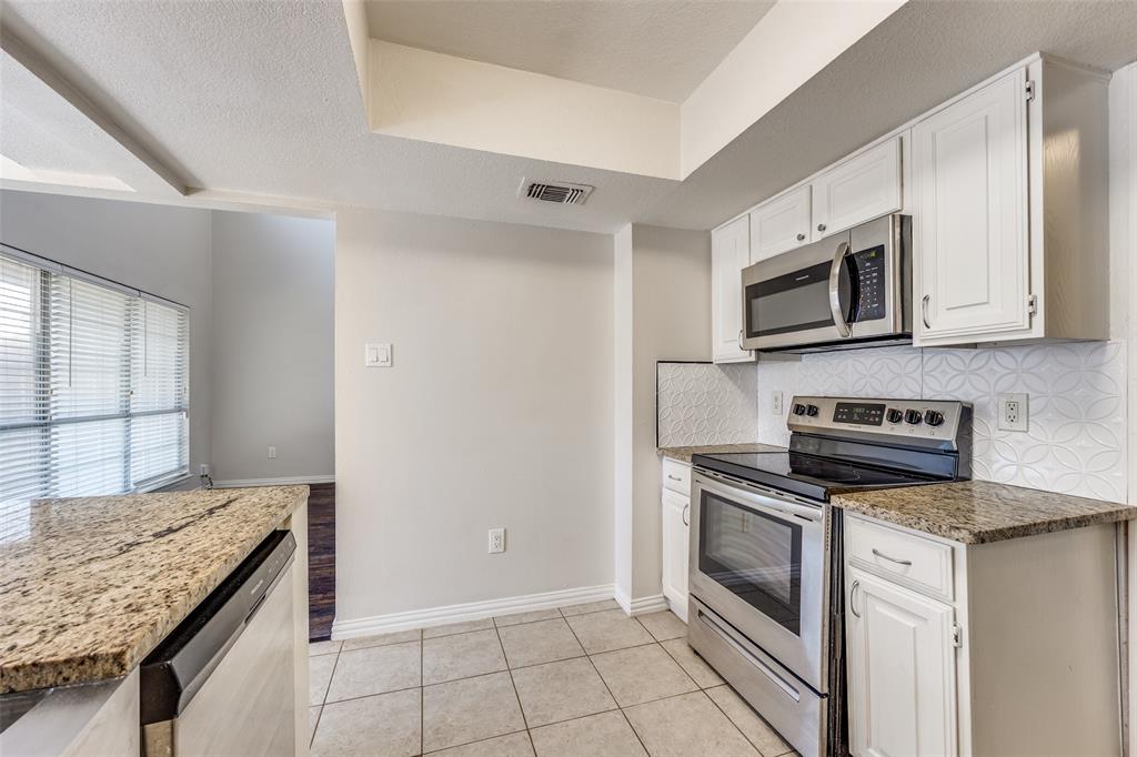 13220 Woodbend Lane Dallas, TX 75243 - Photo 9 of 26 a kitchen with stainless steel appliances granite countertop a stove microwave and sink
