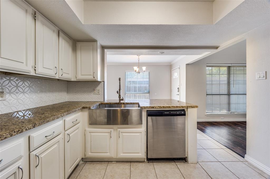 13220 Woodbend Lane Dallas, TX 75243 - Photo 10 of 26 a kitchen with stainless steel appliances granite countertop a stove a sink and white cabinets