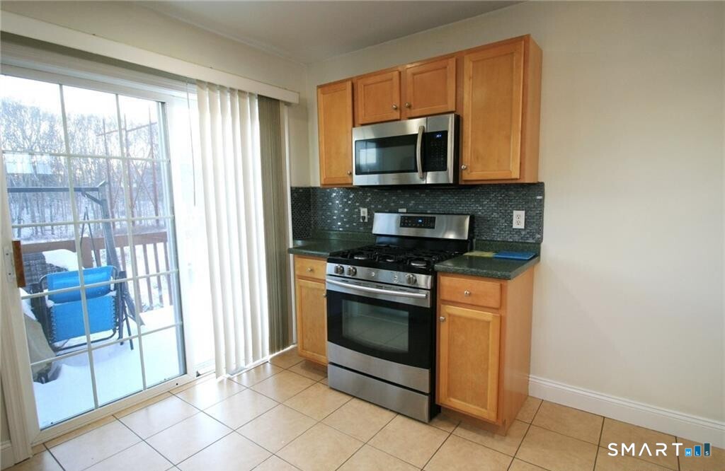 152 Briar Lane, Unit 152 Norwich, CT 06360 - Photo 10 of 33 a kitchen with stainless steel appliances a stove microwave and sink