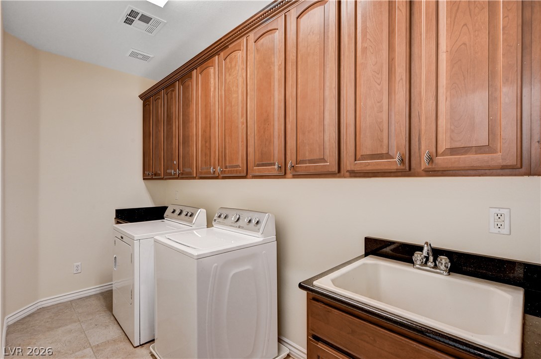 6761 Clay TABLET Street Las Vegas, NV 89149 - Photo 49 of 73 Ample wooden cabinetry and a utility sink highlight this functional laundry space.