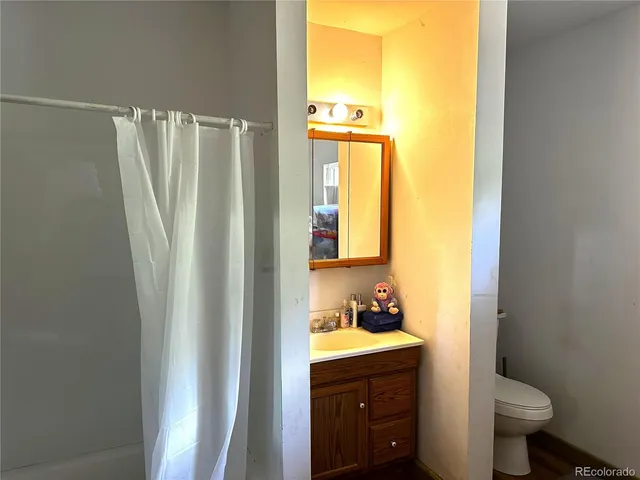 a bathroom with a granite countertop sink toilet and a mirror
