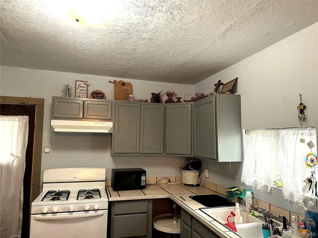 a kitchen with a refrigerator and a stove top oven