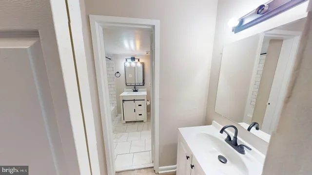 a bathroom with a tub sink vanity and mirror
