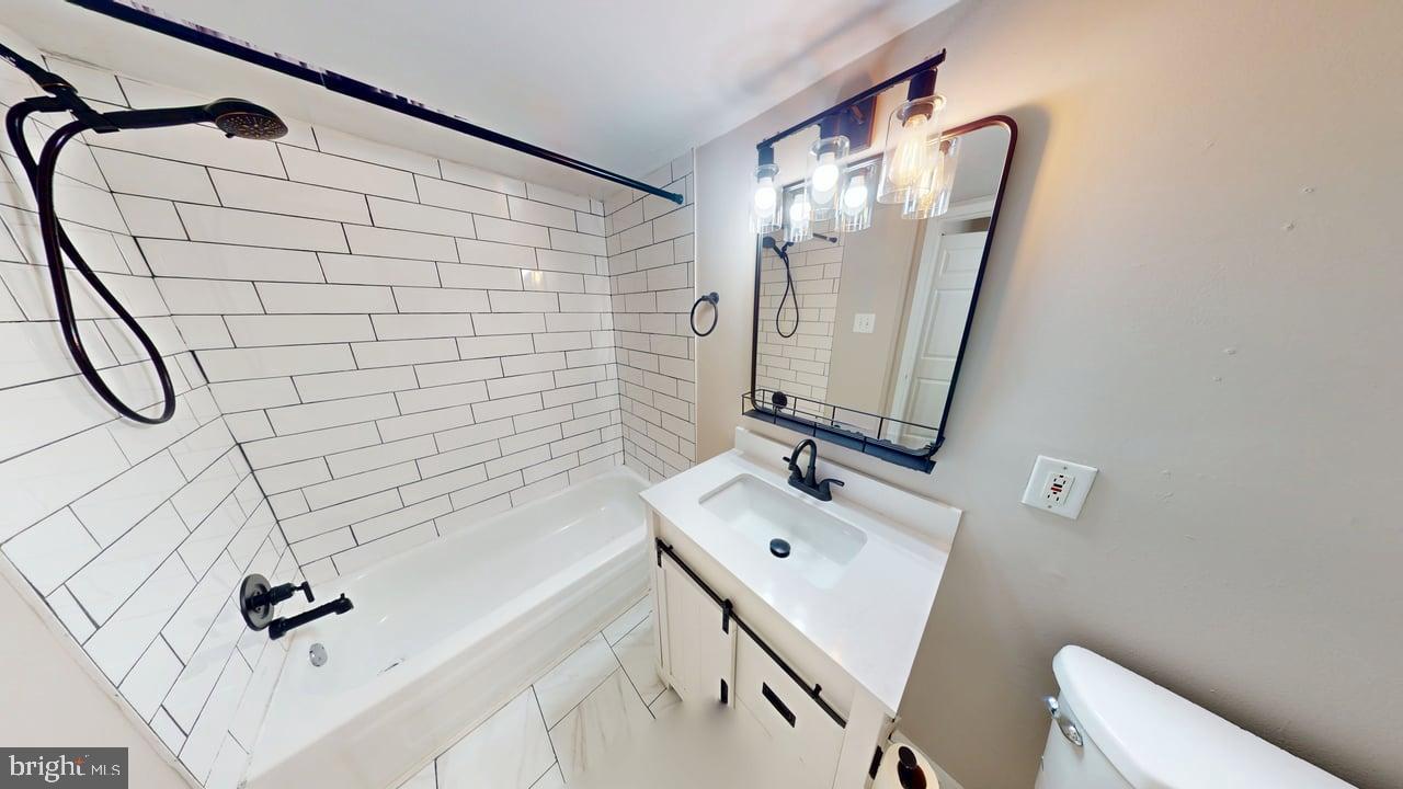 10114 Campus Way South, Unit 201 8C Upper Marlboro, MD 20774 - Photo 15 of 17 a bathroom with a tub sink vanity and mirror