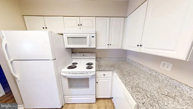 a kitchen with a sink a white cabinets and a window