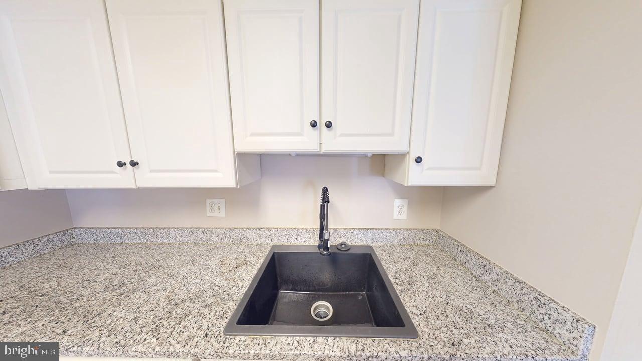 10114 Campus Way South, Unit 201 8C Upper Marlboro, MD 20774 - Photo 6 of 17 a kitchen with a sink a white cabinets and a window