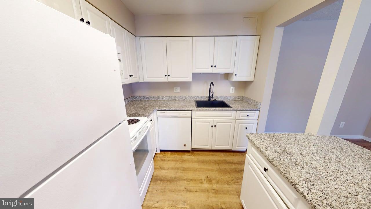 10114 Campus Way South, Unit 201 8C Upper Marlboro, MD 20774 - Photo 7 of 17 a kitchen with a sink stove and cabinets