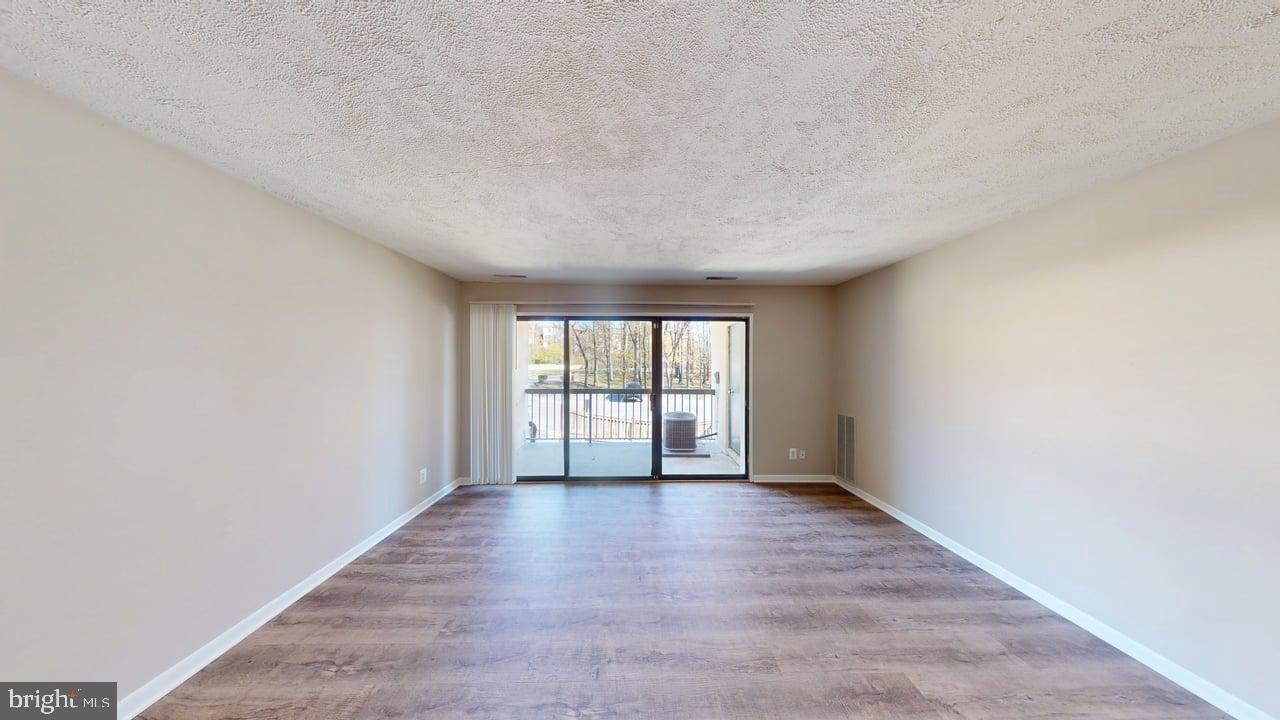 10114 Campus Way South, Unit 201 8C Upper Marlboro, MD 20774 - Photo 8 of 17 an empty room with wooden floor and windows