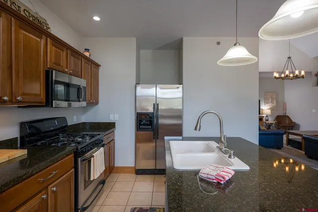 a kitchen with a stove a microwave a sink a refrigerator dining table and chairs