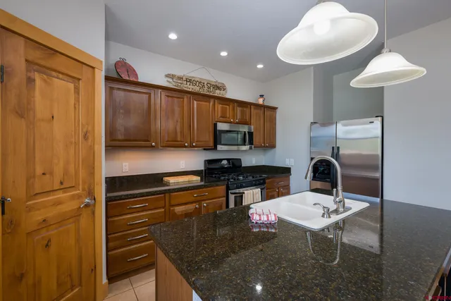 a kitchen with stainless steel appliances granite countertop a sink refrigerator and cabinets