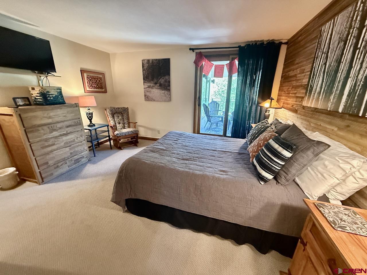 11 Snowmass Road, Unit 337 Crested Butte, CO 81225 - Photo 23 of 35 a bedroom with a bed a flat screen tv and dresser