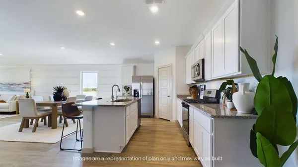 a kitchen with stainless steel appliances granite countertop a stove a refrigerator a sink a dining table and chairs with wooden floor