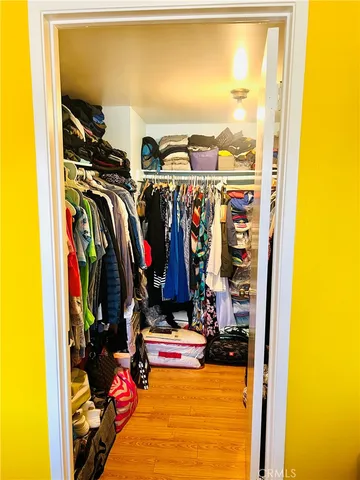 a view of a walk in closet with clothes and shoes