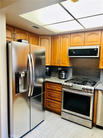 a kitchen with stainless steel appliances granite countertop a stove a refrigerator and a refrigerator