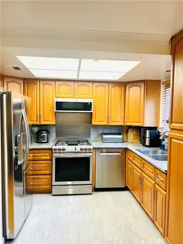 a kitchen with stainless steel appliances granite countertop a sink and a stove