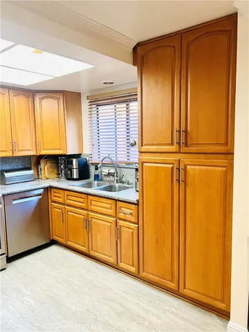 a kitchen with granite countertop cabinets stainless steel appliances and windows