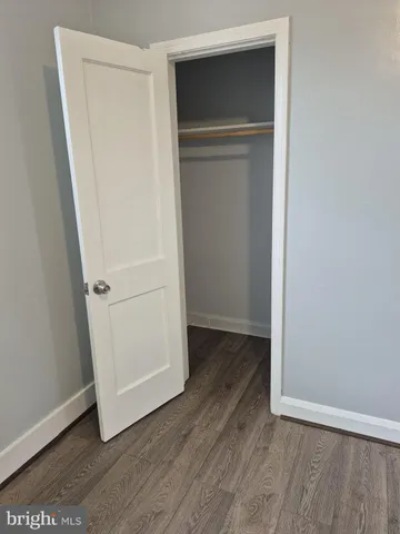 an empty room with wooden floor and closet