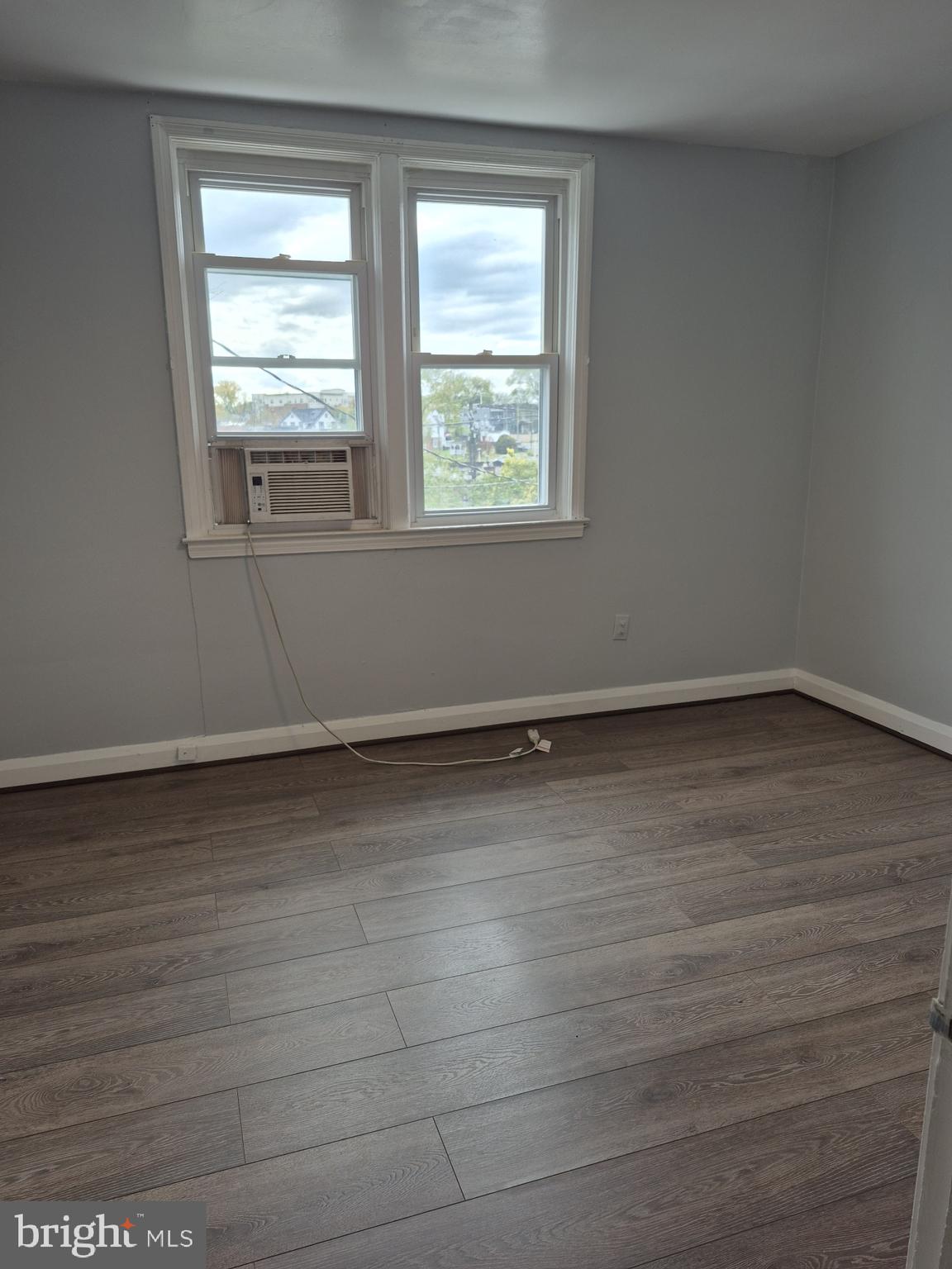 2863 Edgecombe Circle South Baltimore, MD 21215 - Photo 21 of 31 wooden floor in an empty room with a window
