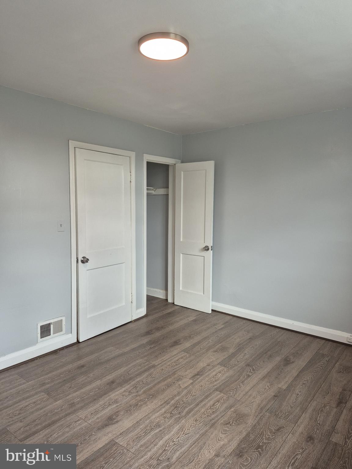 2863 Edgecombe Circle South Baltimore, MD 21215 - Photo 22 of 31 a view of an empty room with wooden floor and a window