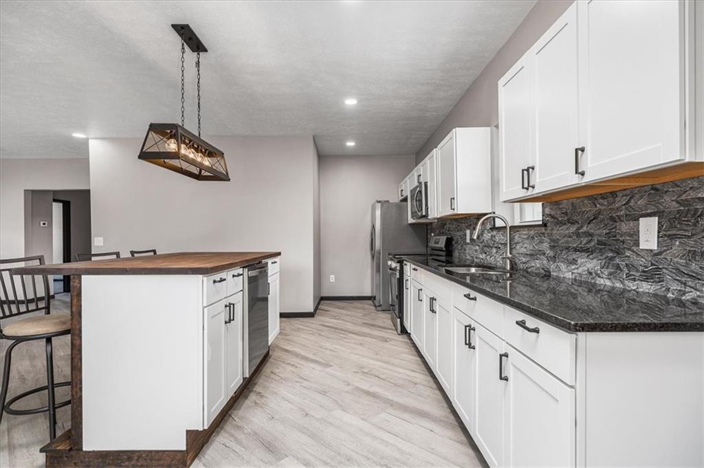 300 3rd Street Langeloth, PA 15054 - Photo 12 of 38 a kitchen with stainless steel appliances granite countertop a sink a stove and a wooden floors