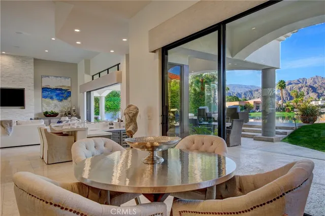 a dining room with furniture a large window and a chandelier