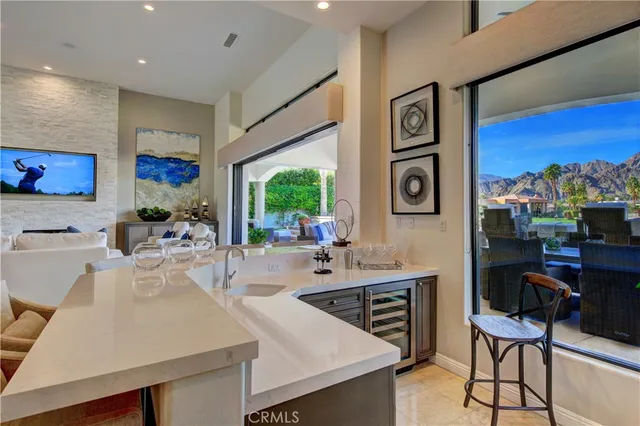 a living room with stainless steel appliances furniture a rug and a view of kitchen