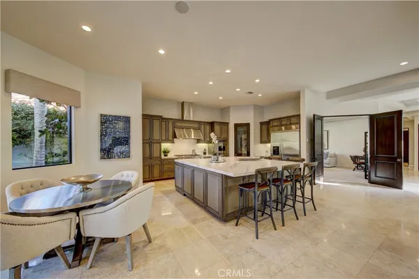 a kitchen with kitchen island a dining table and chairs