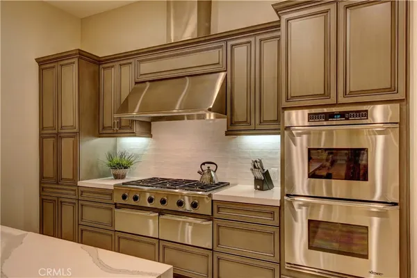 a kitchen with stainless steel appliances granite countertop a stove a refrigerator and cabinets