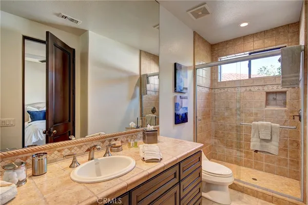 a bathroom with a sink toilet a mirror and shower