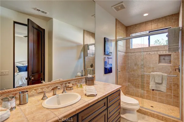 a bathroom with a sink toilet a mirror and shower