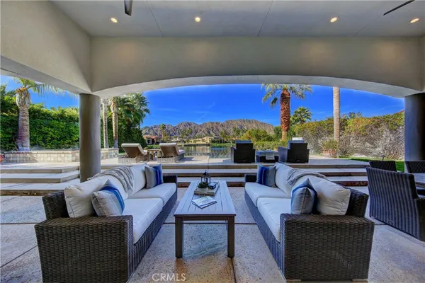 a living room with patio furniture and a floor to ceiling window