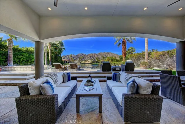 a living room with patio furniture and a floor to ceiling window