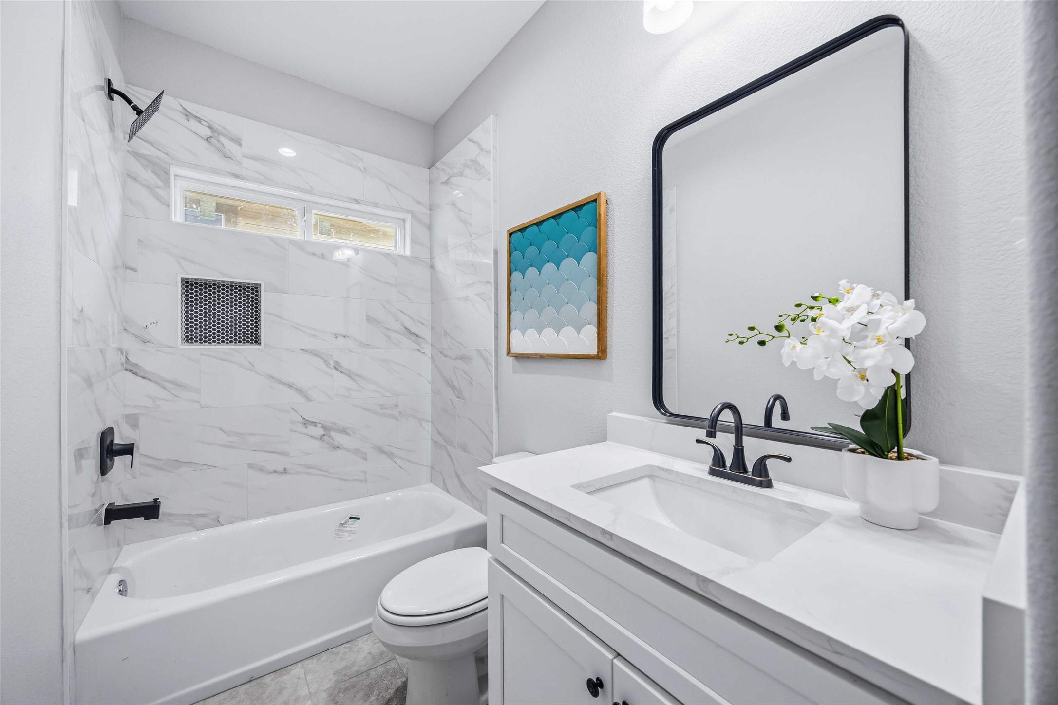 7316 Victoria Street Houston, TX 77020 - Photo 14 of 21 Bath 2 features elegant marble tile and sleek shower/tub combo with black fixtures and great vanity.