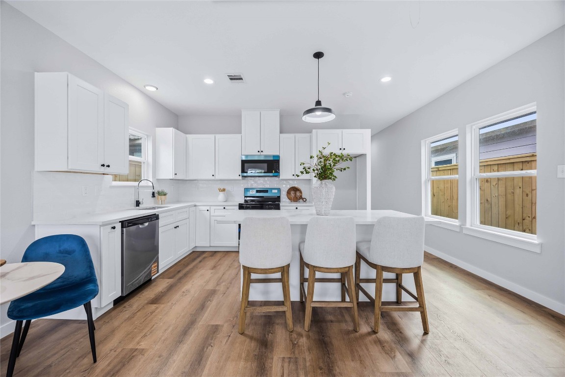 7316 Victoria Street Houston, TX 77020 - Photo 5 of 21 a kitchen with a dining table chairs and white cabinets