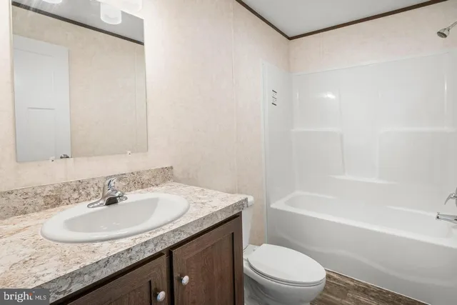 a bathroom with a granite countertop sink a toilet and bathtub