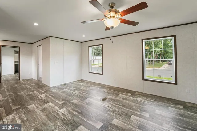 a view of empty room with window and ceiling fan