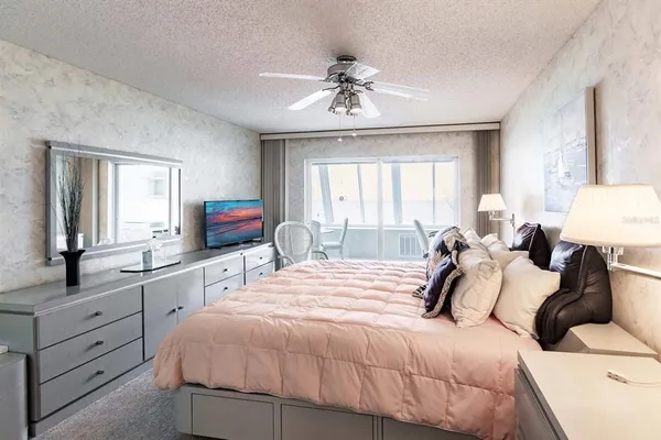 a bedroom with a large bed and a chandelier