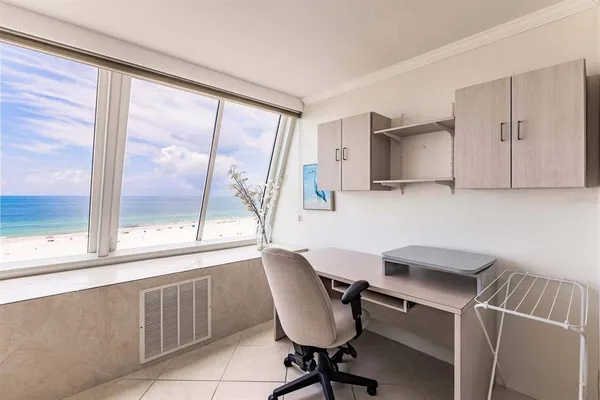 a view of a workspace with furniture and a window