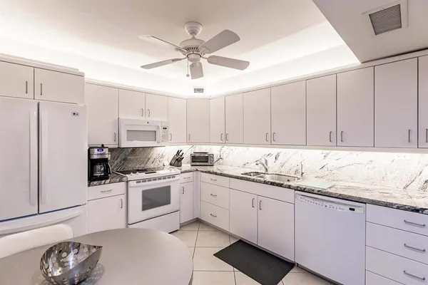 a kitchen with stainless steel appliances granite countertop a sink a stove and cabinets