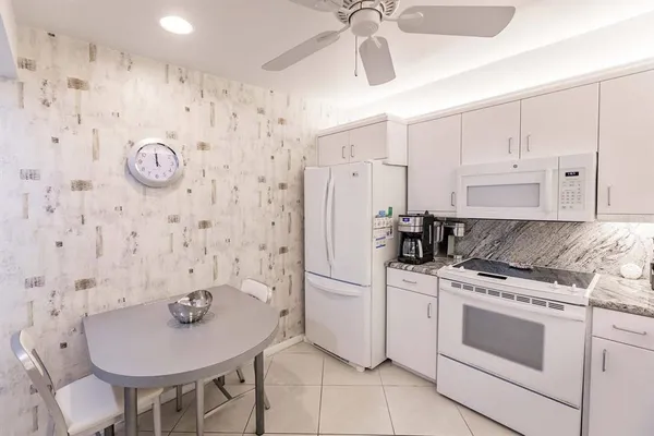 a kitchen with stainless steel appliances granite countertop a stove a refrigerator and a chandelier
