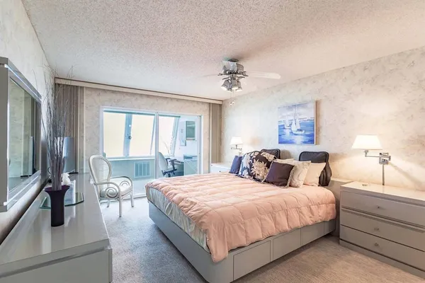 a bedroom with a large bed and a flat tv screen on the dresser